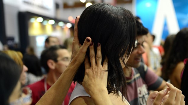 Mulheres testam produto para cabelos nos corredores da Beauty Fair