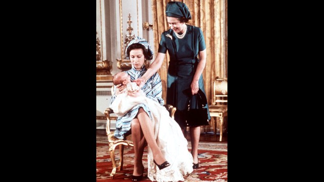 Peter Phillips, o primeiro neto da Rainha Elizabeth II, nos braços da mãe, a princesa Anne (15/10/1977)