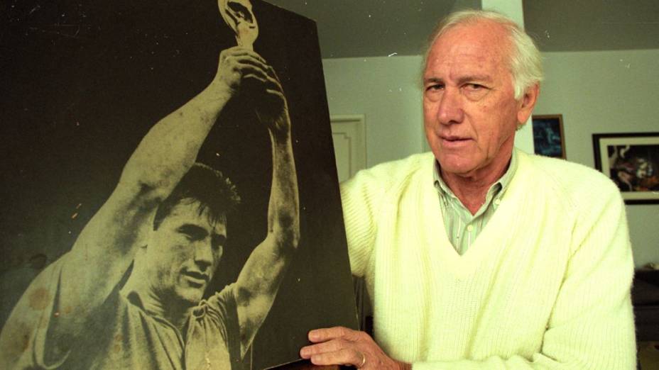 Bellini em 1997, segurando foto em que aparece levantando a taça Jules Rimet na Copa do Mundo de 1958, na Suécia