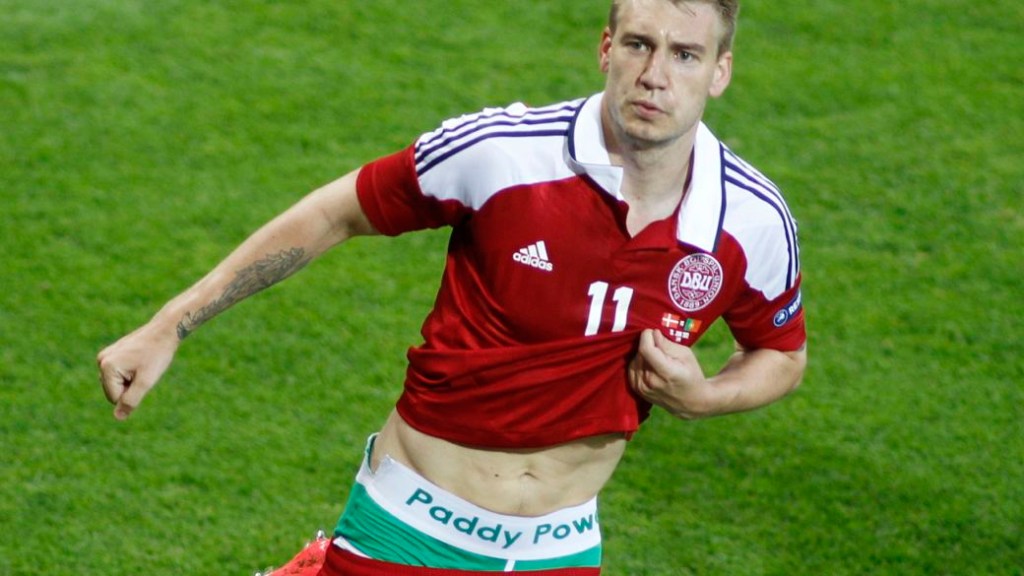 Nicklas Bendtner, da Dinamarca, mostra o logotipo de uma casa de apostas sob a camisa após marcar um gol contra Portugal na Eurocopa 2012