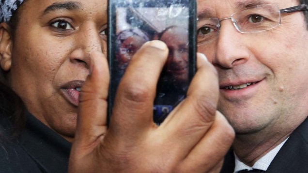 Mulher tira foto com o presidente francês, Francois Hollande, em sua visita à Dijon