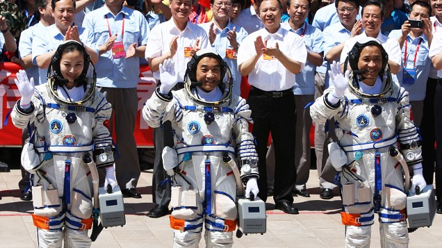 Os astronautas chineses (da esq. para dir.) Wang Yaping, Zhang Xiaoguang e Nie Haisheng acenam para multidão antes de embarcar no foguete Shenzhou-10, no centro espacial de Jiuquan, no norte da China