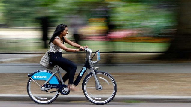 Mulher pedala em um parque de Londres, onde foi iniciado um sistema de aluguel de bicicletas que já conta com 5.000 bikes distribuídas em 315 estações de locação