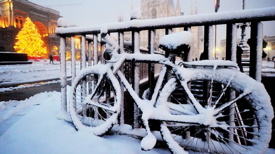 Bicicleta deixada ao ar livre amanhece coberta de neve na Piazza Duomo, na Itália