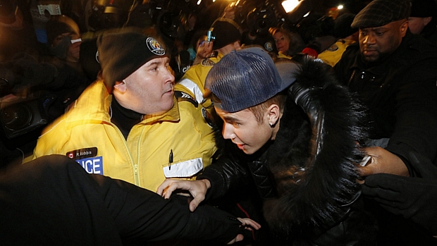 Cercado por policiais e seguranças, Justin Bieber chega à delegacia em Toronto