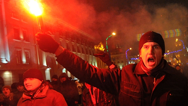 Manifestante acende sinalizador num protesto contra o resultado da eleição presidencial da Bielo-Rússia, em Minsk, no domingo, 19 de dezembro