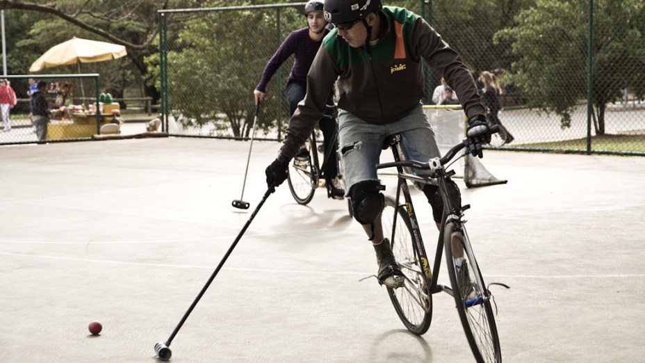 Jogador de Bike Polo tenta conduzir bola durante partida no Parque do Ibirapuera, em São Paulo