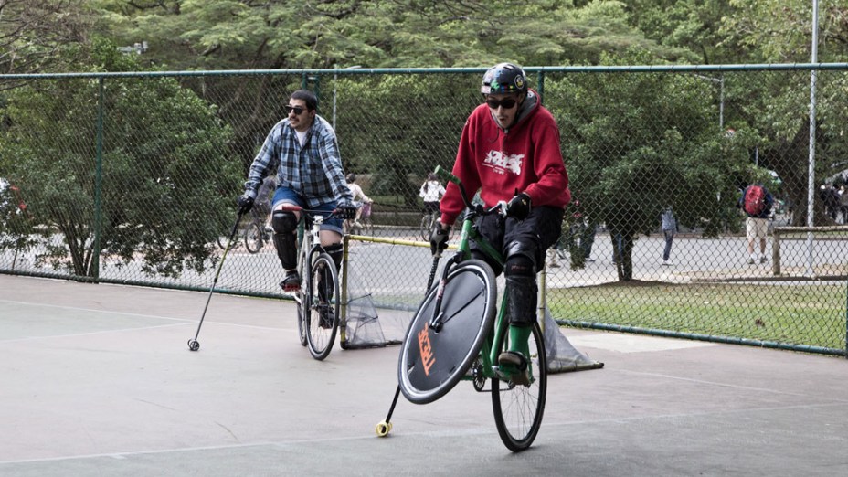Praticante de Bike Polo empina bicicleta se equilibrando com a ajuda do taco, em São Paulo