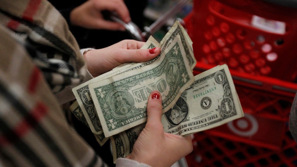 Consumidora conta o dinheiro enquanto espera na fila do caixa da loja Target durante a Black Friday em Connecticut