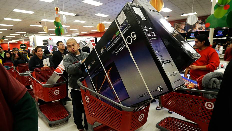 Homem empurra televisores em um carrinho de compras em uma loja Target em Colma, na Califórnia no Dia de Ação de Graças na Black Friday