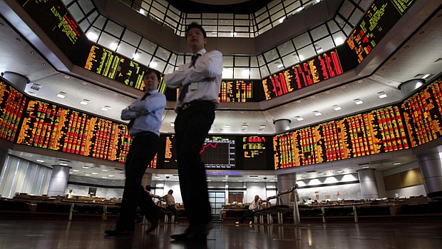 Investidores observam painel eletrônico da Bolsa de Valores da Malásia, em Kuala Lumpur: alta no mercado asiático nesta quinta-feira