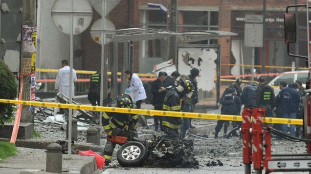 Policiais colombianos inspecionam o local da explosão de um carro bomba em Bogotá, na Colômbia, que ocorreu na madrugada desta quinta-feira e atingiu uma estação de rádio e edifícios da região