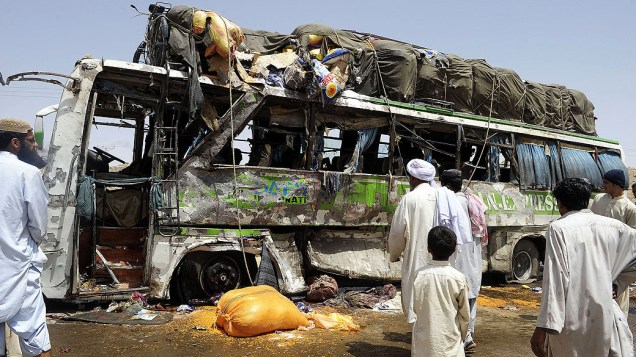Paquistaneses observam nesta segunda-feira restos de ônibus alvo de bomba ativada por controle remoto em Mastung, no Paquistão. Pelo menos seis pessoas morreram e cerca de 50 ficaram feridas