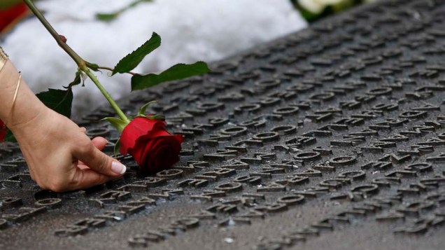 Mulher leva flores para o memorial das vítimas do atentado construído no Hyde Park, em Londres