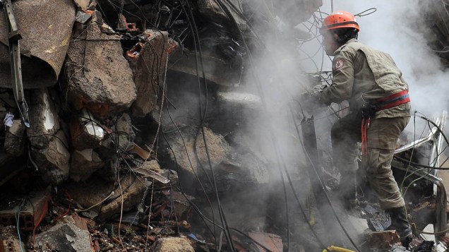 Bombeiro trabalha no local em que três prédios desabaram no Rio de Janeiro