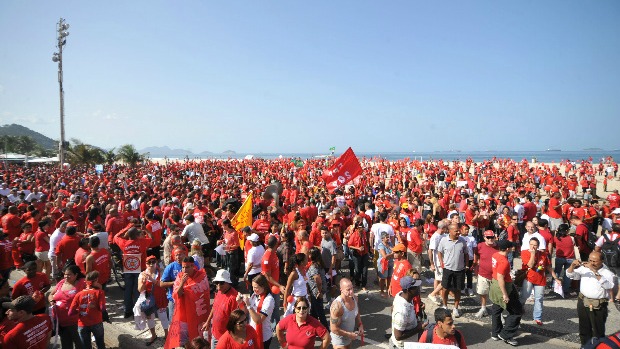 Bombeiros: manifestantes vestidos de vermelho se aglomeram na praia de Copacabana