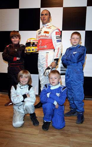 Reprodução do piloto de F1 Lewis Hamilton é fotografada ao lado de crianças em Londres.