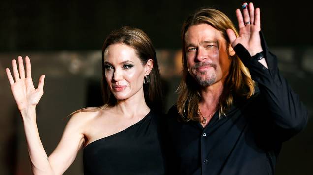 O casal de atores Angelina Jolie e Brad Pitt acenam para os fãs durante estréia do filme Guerra Mundial Z em Tóquio, no Japão