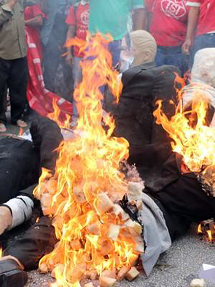 Boneco de Joaquim Levy é queimado durante protesto