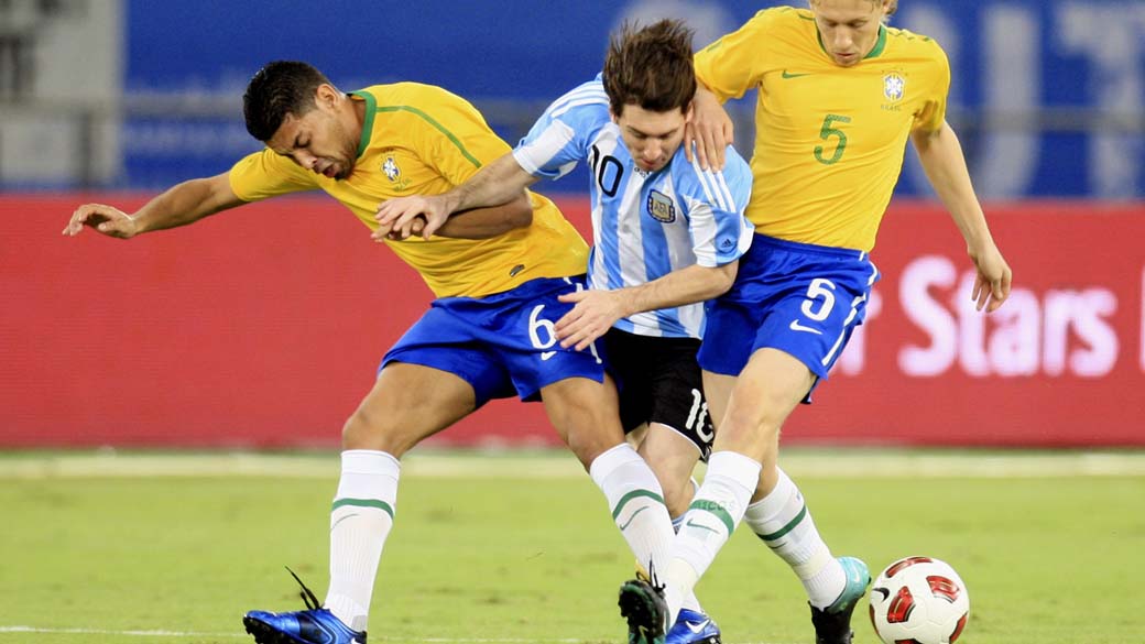 Messi entre Andre Santos e Lucas durante amistoso Brasil e Argentina