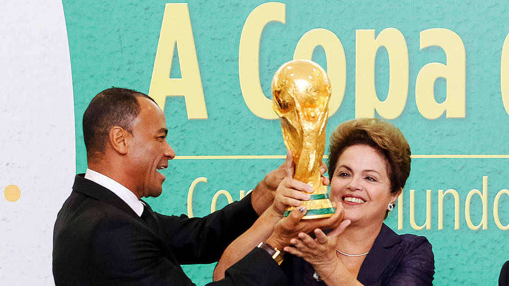 Presidente Dilma Rousseff levanta a taça da Copa do Mundo ao lado do ex-jogador Cafu, no Palácio do Planalto