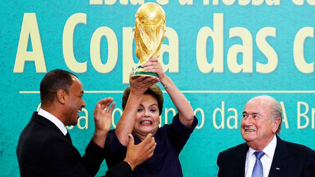 Presidente Dilma Rousseff levanta a Taça da Copa do Mundo nesta segunda-feira (2), durante apresentação oficial pelo presidente da Fifa, Joseph Blatter, no Palácio do Planalto em Brasília