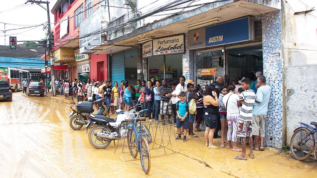 Pessoas formam fila em uma lotérica em Nova Iguaçu, após fortes chuvas atingirem o Rio de Janeiro
