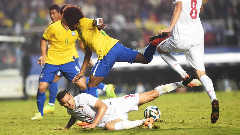 Jogador da Sérvia dá um carrinho em William, durante amistoso no estádio do Morumbi em São Paulo