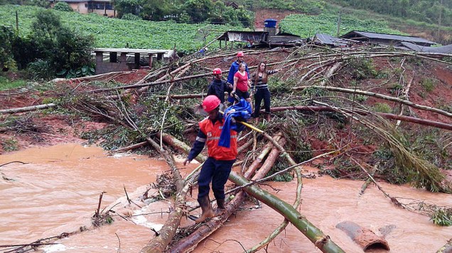 Imagem cedida pela prefeitura de Santa Maria de Jetibá, no Espírito Santo, mostra uma equipe da Defesa Civil ajudando uma família a fugir das inundações provocadas pelas fortes chuvas que atingem o estado