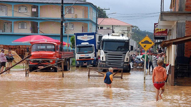 Imagem cedida pela prefeitura de Santa Maria de Jetibá, no Espírito Santo, mostra moradores caminhando por ruas alagadas em consequência das fortes chuvas que atingem o estado