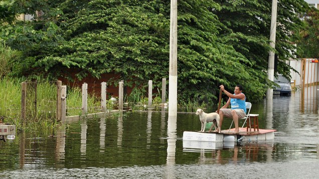 Imagem cedida pela prefeitura de Vila Velha, mostra um homem em uma embarcação improvisada pelas ruas inundadas do Jardim Garanhuns, afetadas pelas fortes chuvas que atingem estado do Espírito Santo