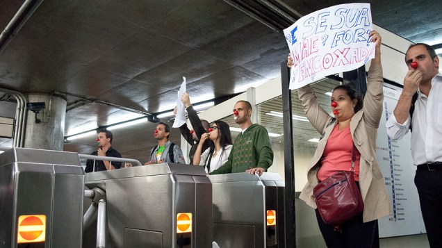 Com narizes de palhaço, apitos e cartazes na mão, grupo manifesta revolta contra "encoxadores"