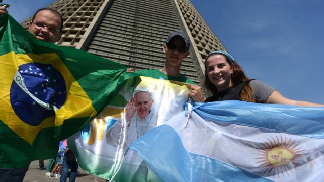 Fiéis com as bandeiras do Brasil e da Argentina aguardam a chegada do papa Francisco no Rio de Janeiro