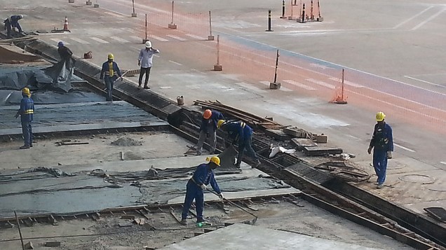 Operários trabalham ao lado da pista de pouso do Aeroporto Internacional Marechal Rondon (MT)