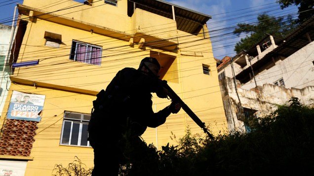 Policial ocupa posição no complexo de favela do Lins durante uma operação para instalar Unidade de Manutenção da Paz da Polícia (UPP) na região, no Rio de Janeiro
