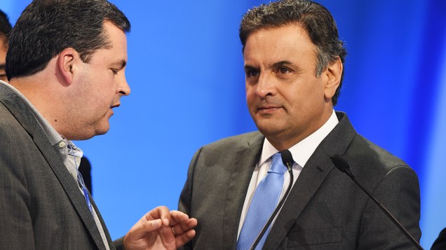 O candidato do PSDB à Presidência da República, Aécio Neves, recebe orientações de seus assessores durante o intervalo do debate promovido pela Rede Record neste domingo (28), em São Paulo