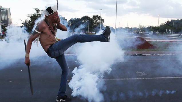 Manifestante chuta uma bomba de gás lacrimogênio lançada pela polícia, durante protesto dos índios em Brasília