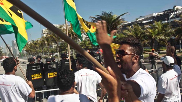 Manifestantes protestam diante dos homens da Força Nacional que fazem a segurança do hotel em que será realizado o leilão de Libra, nesta segunda