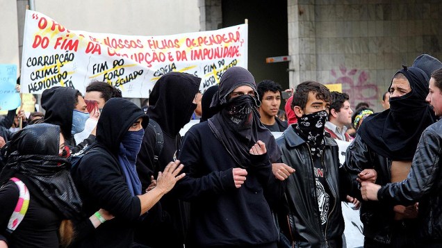 Curitiba - Manifestantes cobrem o rosto durante protesto do desfile militar de 7 de Setembro