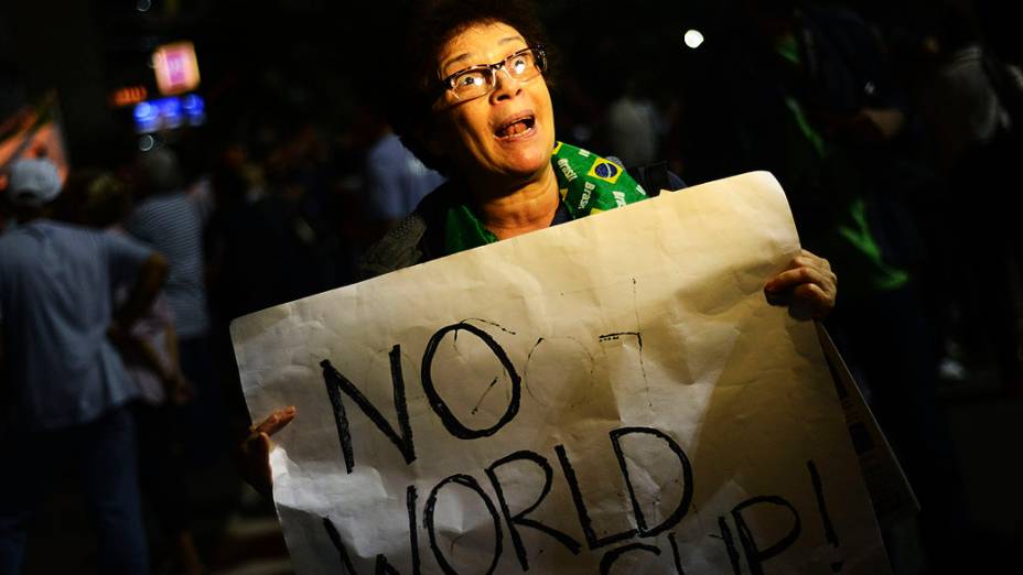 Manifestante segura um cartaz escrtio: Não Copa do Mundo, durante um protesto contra o governador do Rio de Janeiro, Sergio Cabral, na frente de sua residência no bairro do Leblon, no Rio de Janeiro
