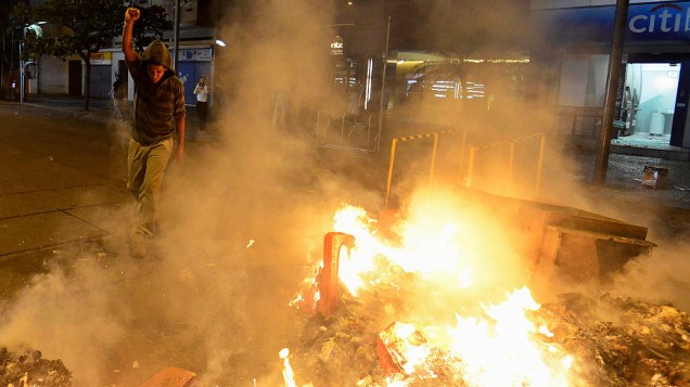 Manifestante faz uma fogueira com lixos durante um protesto contra o governador do Rio de Janeiro, Sergio Cabral, na frente de sua residência no bairro do Leblon, no Rio de Janeiro