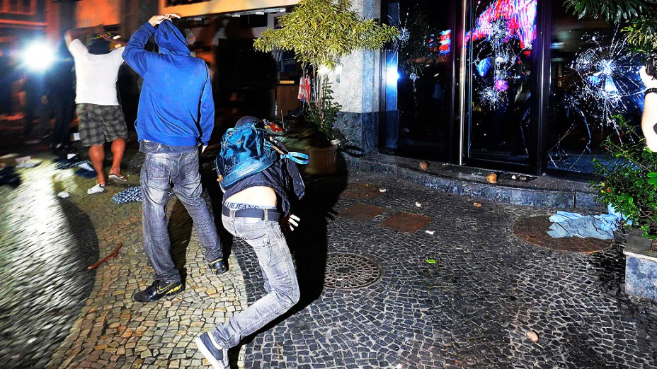 Vândalos atiram pedras em uma loja durante um protesto contra o governador do Rio de Janeiro, Sergio Cabral, na frente de sua residência no bairro do Leblon, no Rio de Janeiro