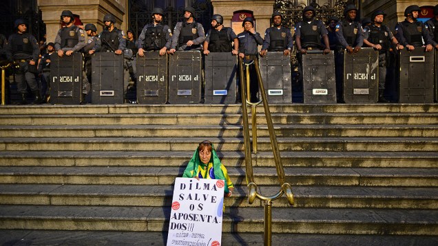 Rio de Janeiro - Mulher segura cartaz com uma mensagem para a presidente Dilma Rousseff, na escadaria do Teatro Municipal, nesta quinta-feira (11)