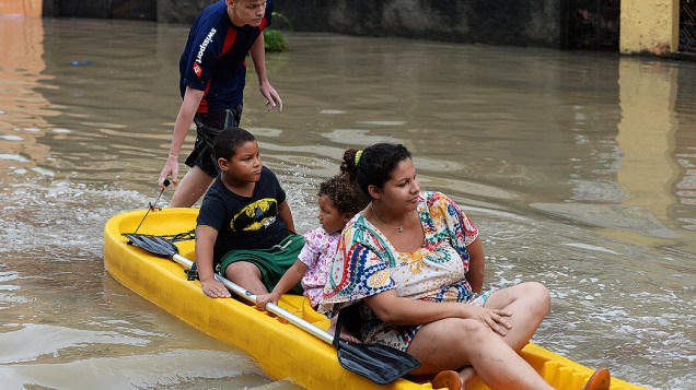 Família é resgatada em uma rua inundada no subúrbio do Rio de Janeiro nesta quarta-feira (11)