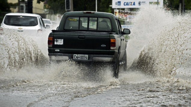 Caminhonete atravessa rua inundada no subúrbio do Rio de Janeiro, nesta quarta-feira (11)