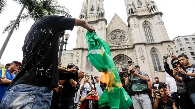 Manifestante queima uma bandeira do Brasil, durante a Marcha Antifascista na Praça da Sé, em São Paulo