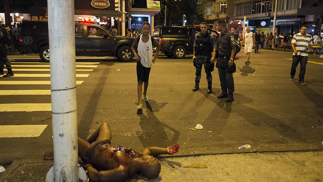 Mulher se aproxima de seu marido, Adilson Rufino da Silva, 34 anos, ferido durante um tiroteio com policiais na praia de Copacabana no Rio de Janeiro durante as comemorações do Ano Novo
