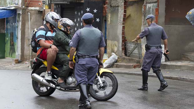 Policiais revistam motoqueiros na favela de Paraisópolis, em São Paulo