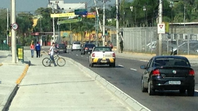 Bicicleta cruza a pista na faixa do BRT: risco para a população dos bairros cortados pelo corredor expresso