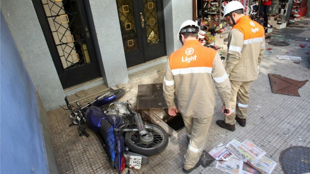 Técnicos da Light isolaram a área do bueiro onde houve a explosão, na Rua Camuirano, em Botafogo: homem de 26 anos ficou ferido